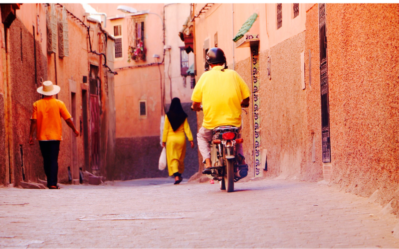 Motorista con la moto en una calle de Marrakech 